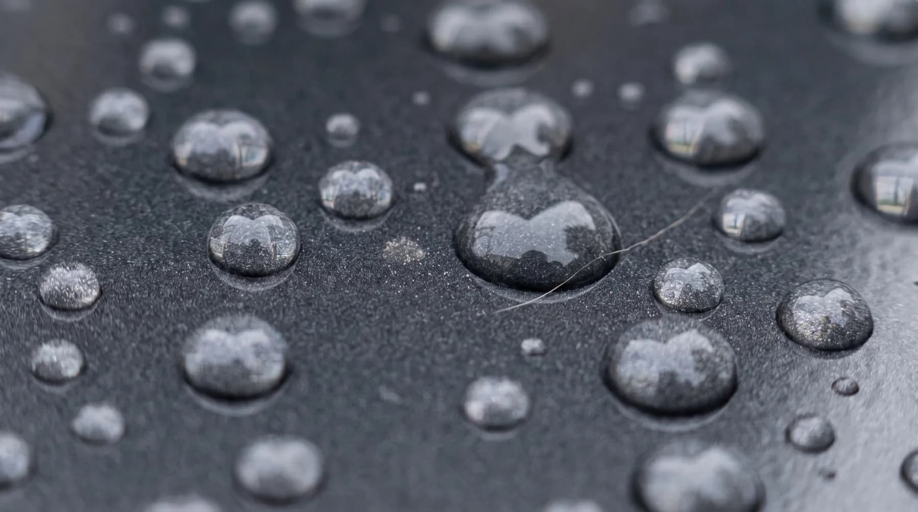 Waterdruppels die hoog en rond op een gecoate lak blijven staan
