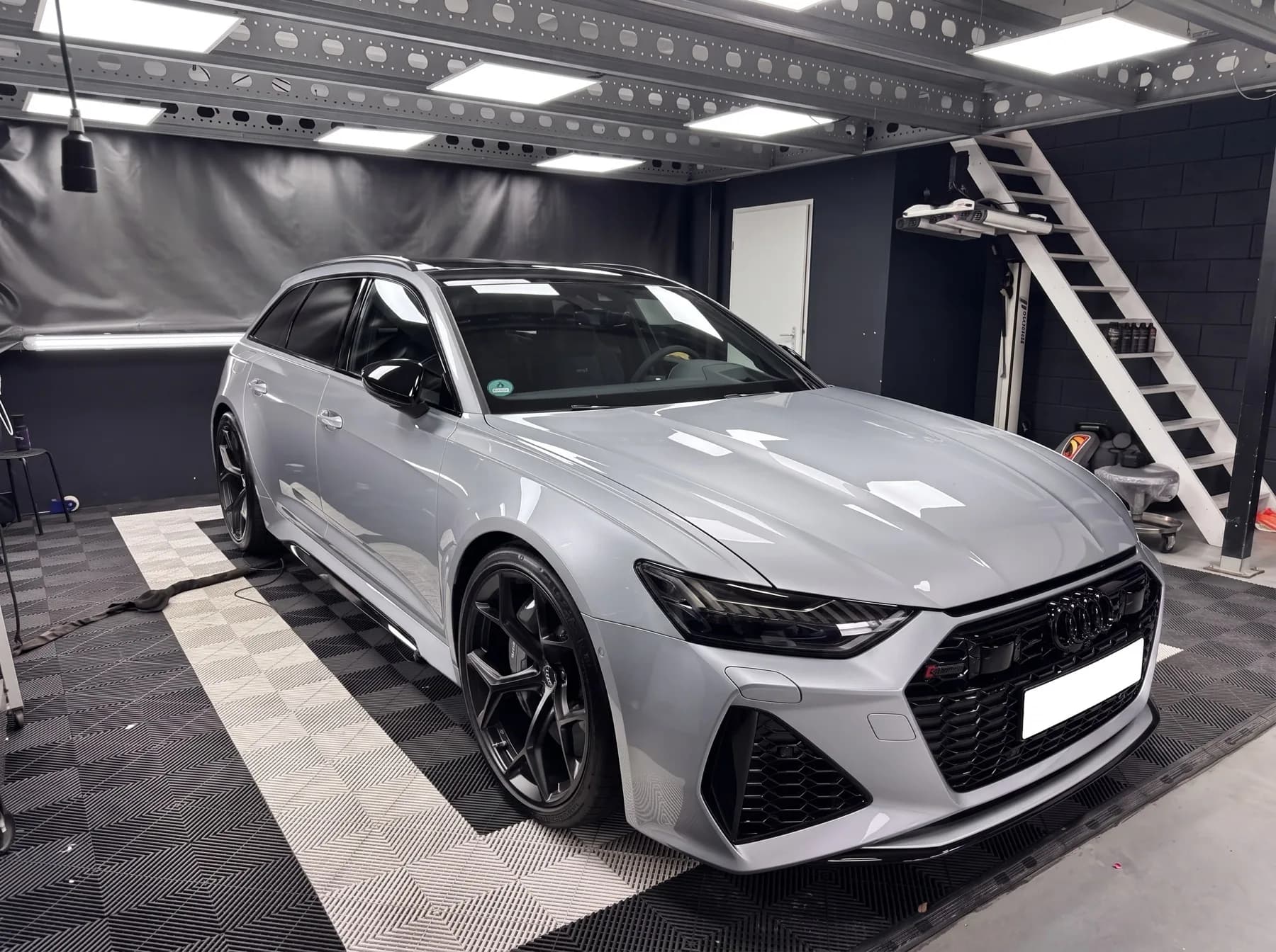 Grijze Audi RS6 na een volledige detailing, met gereinigde velgen en vlekvrije ruiten in een werkplaats
