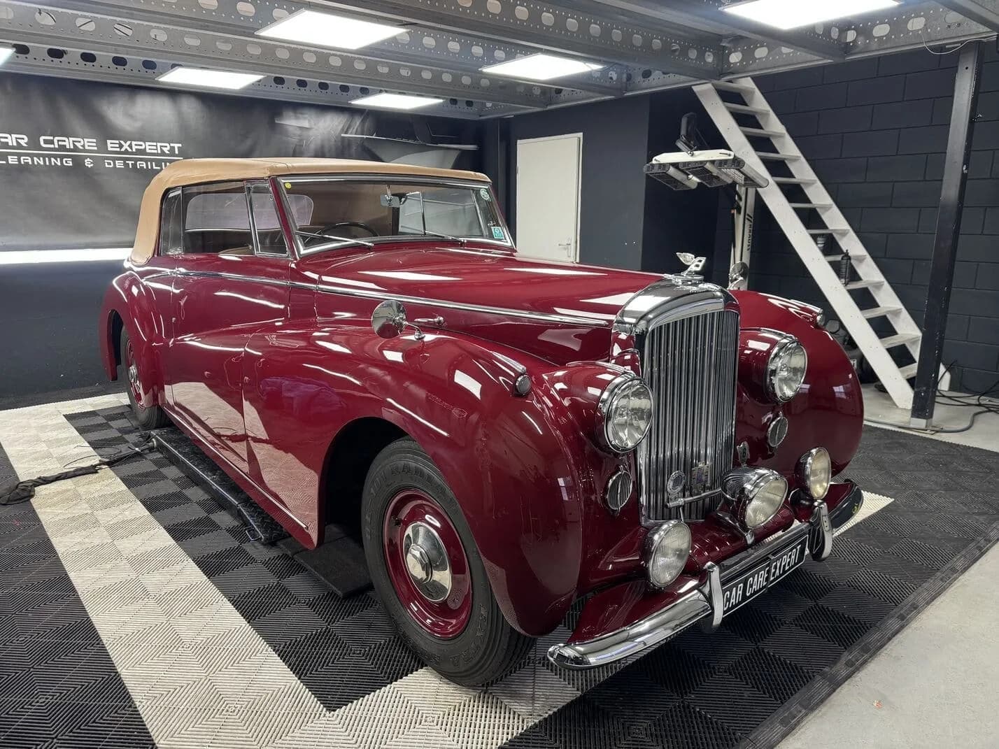 Polijstmachine op het donkerrode spatbord van een Bentley oldtimer