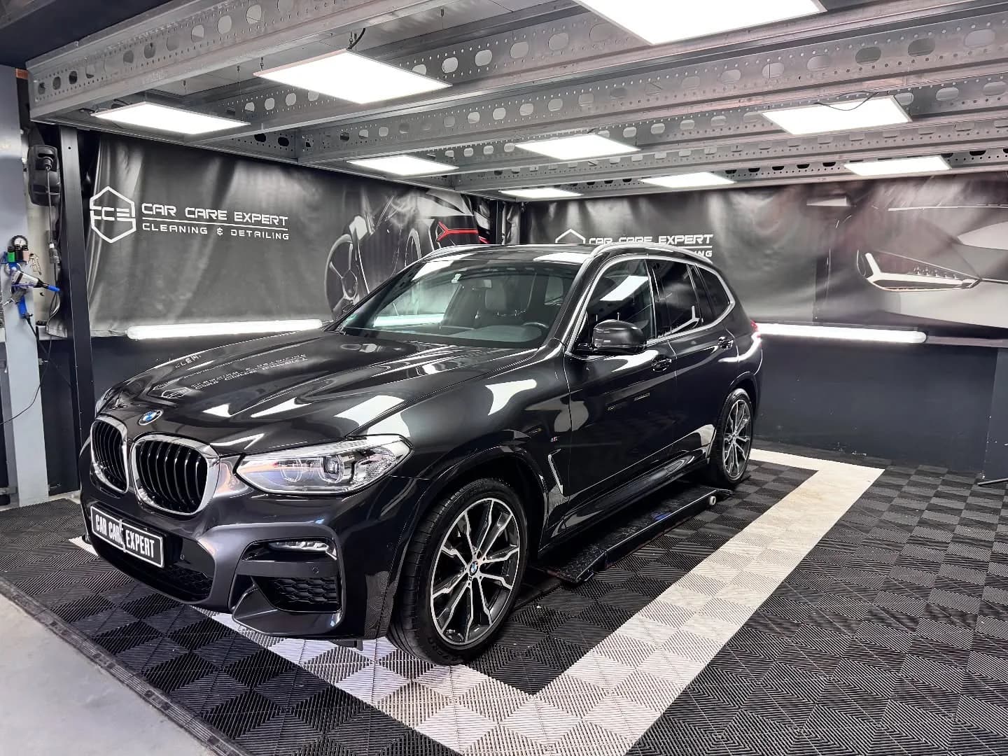 Zwarte BMW X3 in driekwart aanzicht in de detailingstudio na de tweestaps polijstbeurt