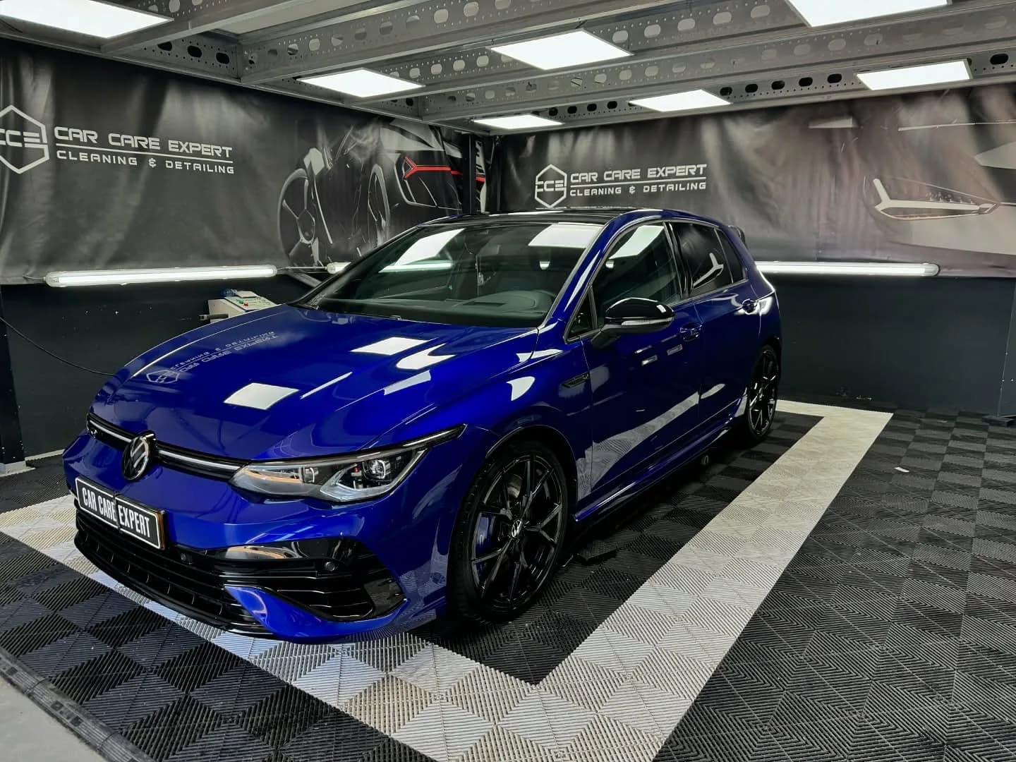 Blauwe Volkswagen Golf R in driekwart aanzicht in de detailingstudio na de behandeling