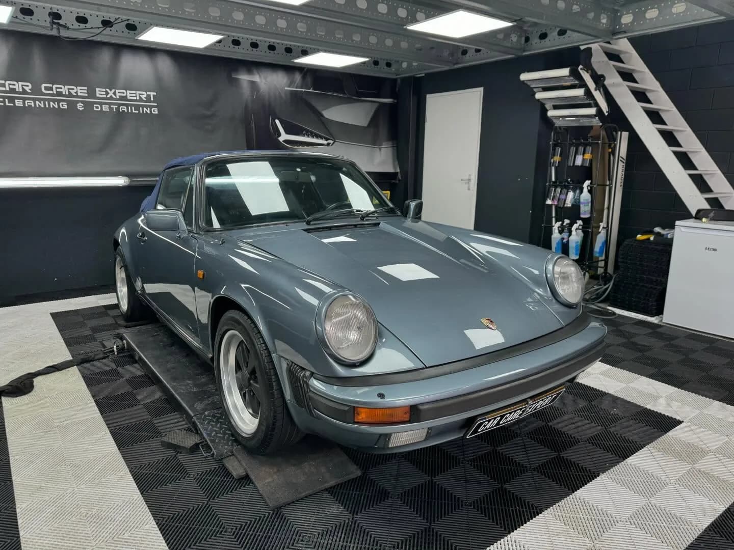 Grijsblauwe Porsche 911 SC in driekwart aanzicht met scherpe reflecties in de flank