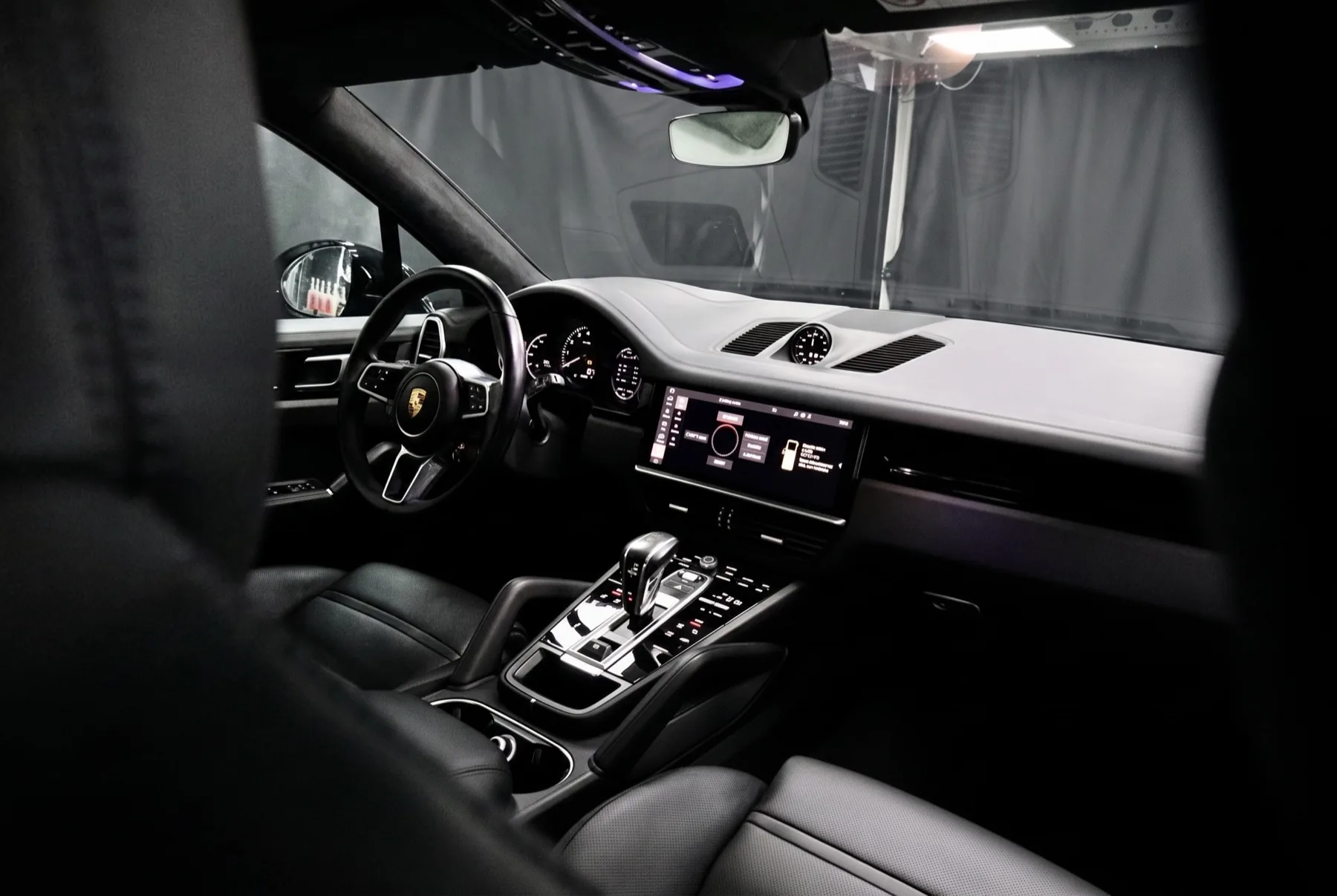 Gereinigd Porsche-interieur met zwart leer, waarin het dashboard en de middenconsole vlekvrij zijn