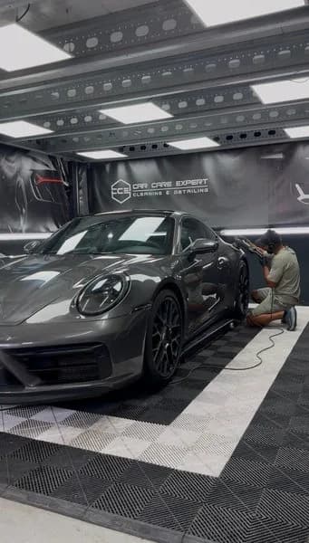 Polijstmachine op de donkergrijze lak van een Porsche 911